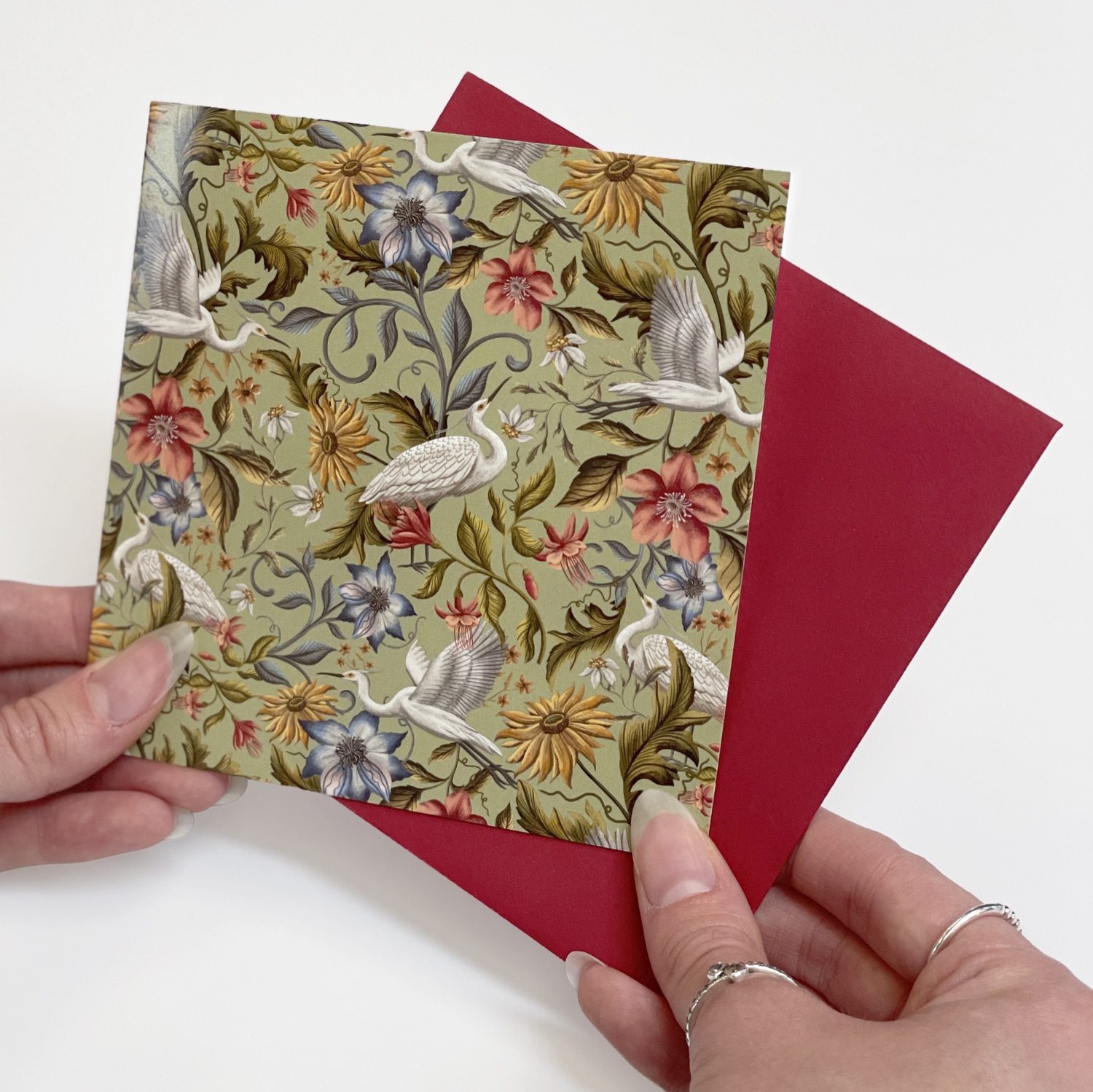 A green floral heron greeting card with a red envelope