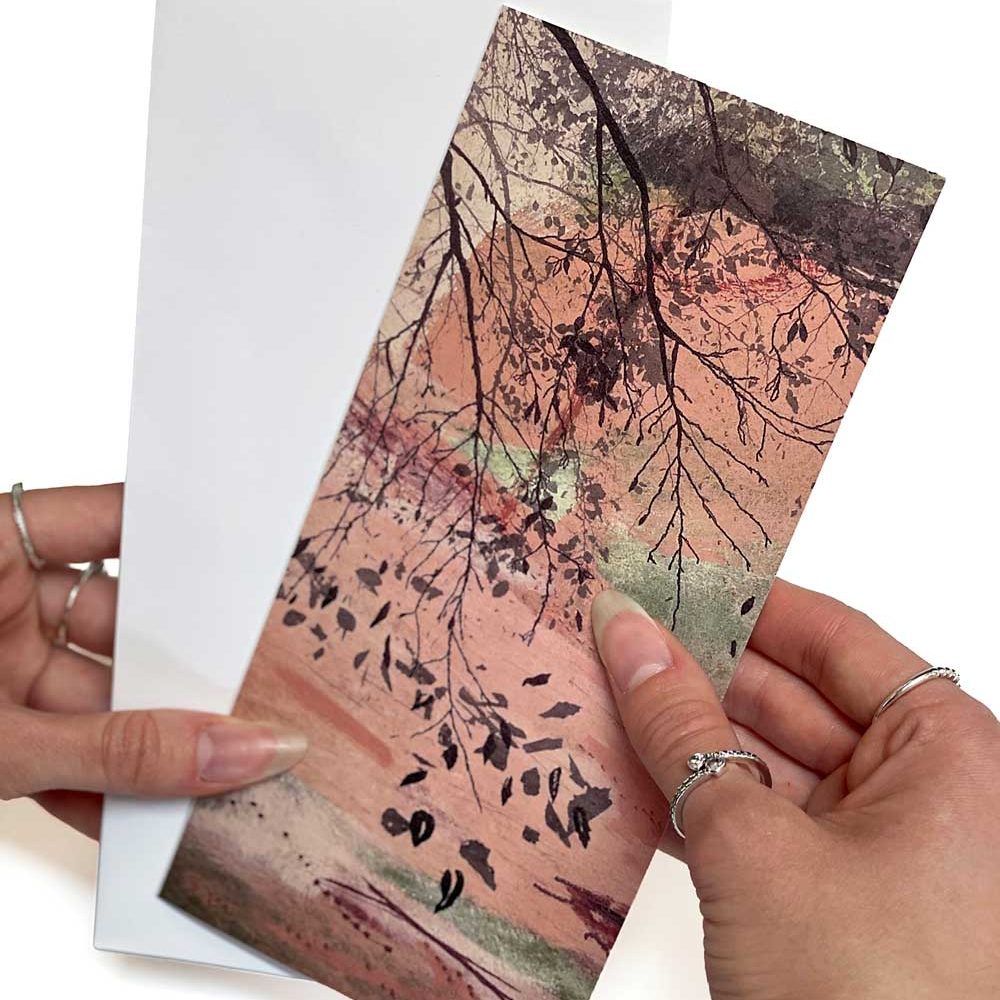 A slim tall greeting card of pink woodland branches, with a white envelope