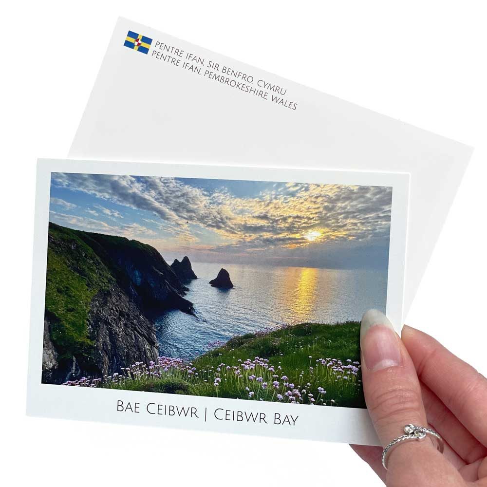 A Ceibwr Bay photographic postcard with a bilingual Welsh and English caption